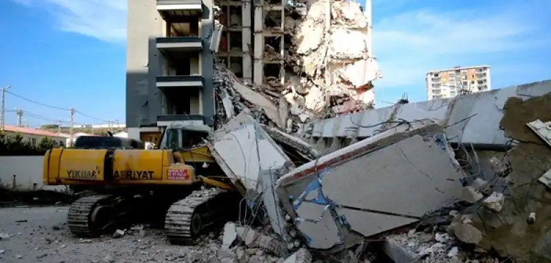 Hatay'da Ağır Hasarlı Bina Yıkım Sırasında Iş Makinesinin üzerine Devrildi